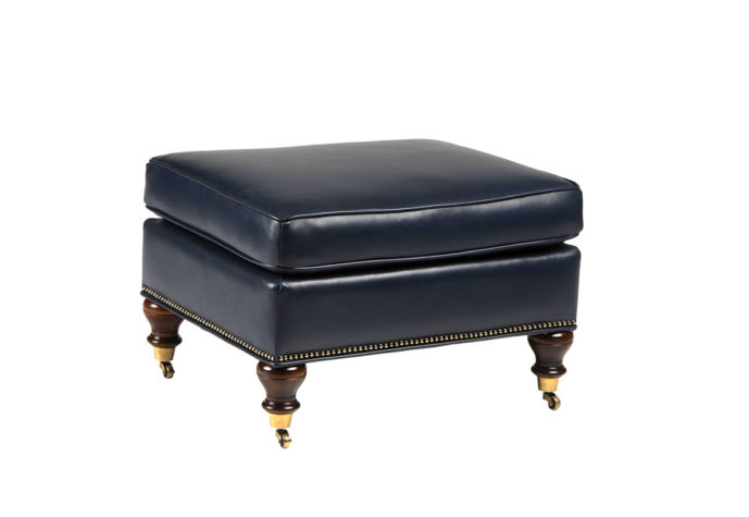 Rafferty ottoman is a traditional style with nailhead trim and wood finishes shown in black leather