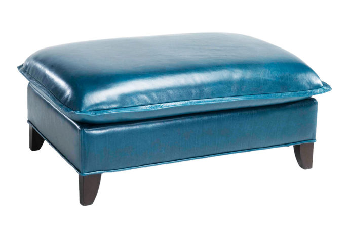 Angled shot of the large blue leather Genevieve ottoman by Vogel with espresso wood finish