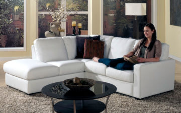 westend sectional is a transitional sectional in white leather with lady sitting on the sectional
