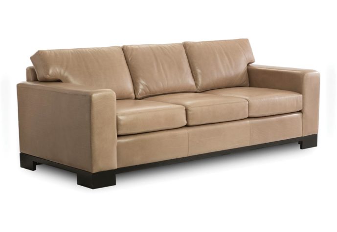 Angled shot of the contemporary Julius sofa from Vogel by Chervin in a tan leather and espresso wood finish