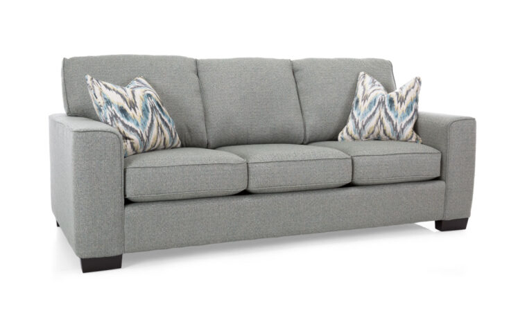 2483 sofa from decor rest, a canadian sofa manufacturing company, showcases a light grey fabric on the sofa accented with blue and grey chevron pillows