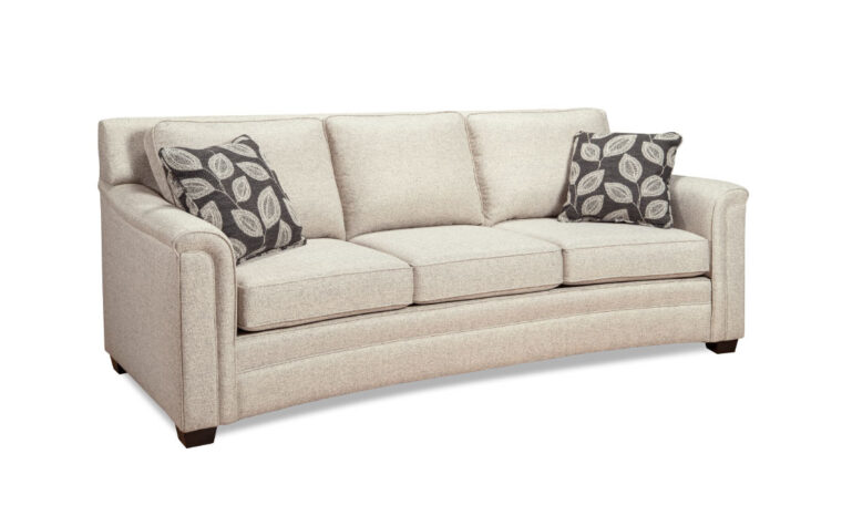 Fabric curved sofa with semi-attached back cushions and throw pillows.