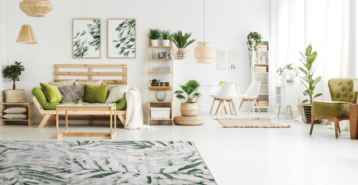 Antika II Area Rug by Kalora - palm branch pattern overlaid on cream background - rug on white floor with Scandinavian wooden furniture and decor