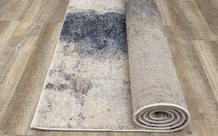 Breeze II Area Rug by Kalora - floor rug with marbled design of cream, black, brown, and teal blue (rolled up)
