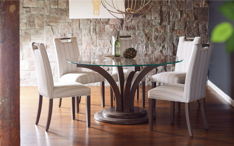 Round Glass Table II by Bertanie - glass table top resting on an elegant, splaying out wooden pedestal; surrounded by 4 upholstered side chairs with dark wood legs and cream fabric