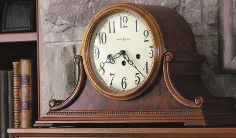 Howard Miller Mantle Clock - medium brown finish - sitting on mantle next to bookshelf