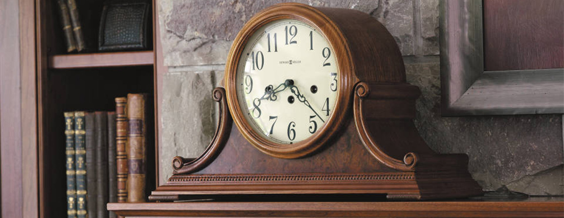 Howard Miller Mantle Clock - medium brown finish - sitting on mantle next to bookshelf