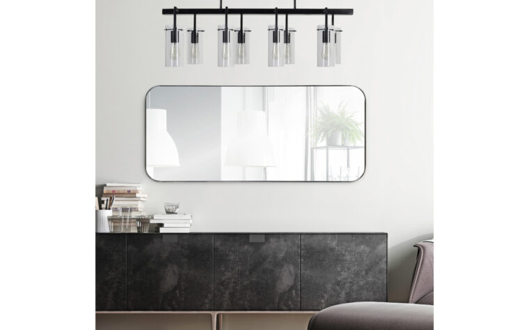 Delphinus Mirror - Renwil - rounded rectangle, full length mirror with thin metal frame; hanging on white wall above server with leather door fronts, beneath industrial ceiling light fixture and next to mauve mid-century modern furniture