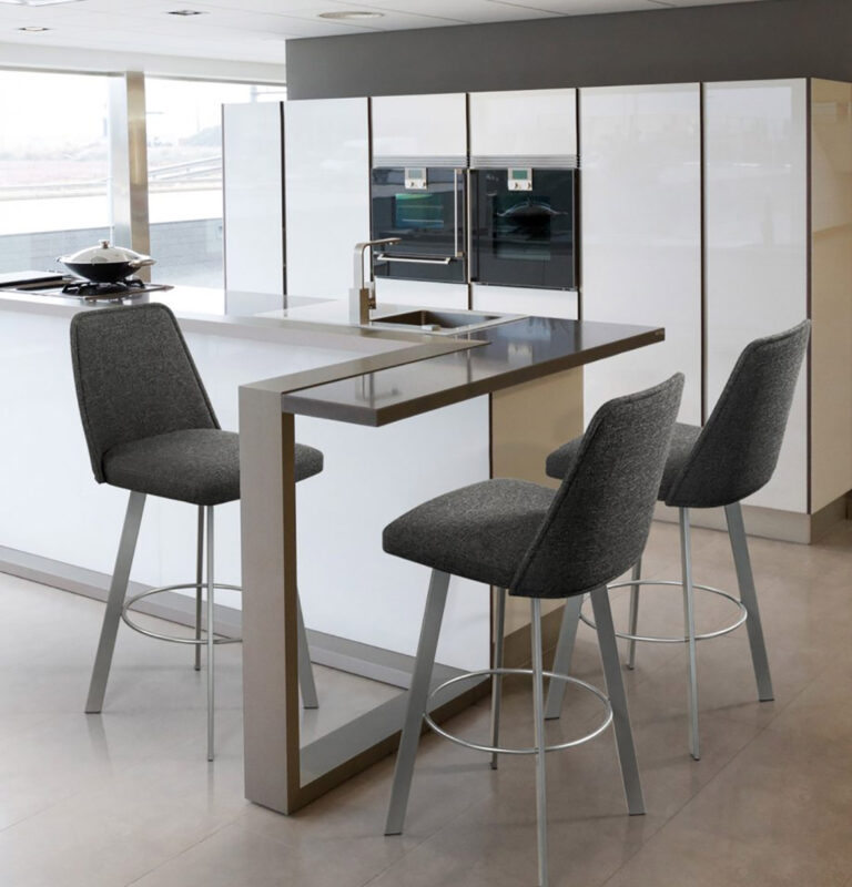Trica Sofia barstools with full backs upholstered in grey fabric and stationed around a glass-top peninsula in a white, high gloss, condo kitchen