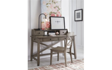 9950-6100 - Farmhouse Desk - lightly antiqued taupe finish on streamlined kids' desk with 2 drawers and an open x-feature on the back side; staged with hutch, matching chair in kids' white bedroom with soft pink accents