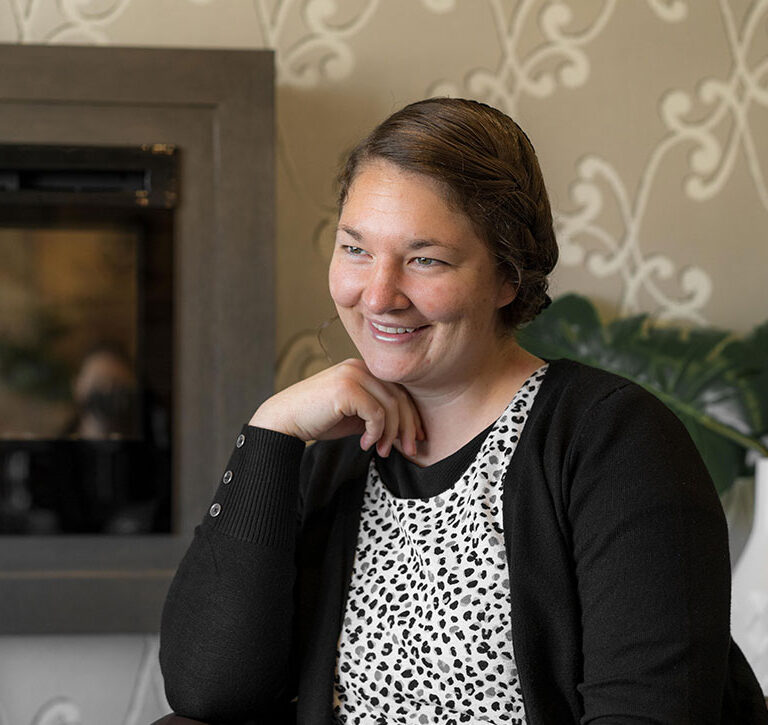 Jody S. sitting by fireplace