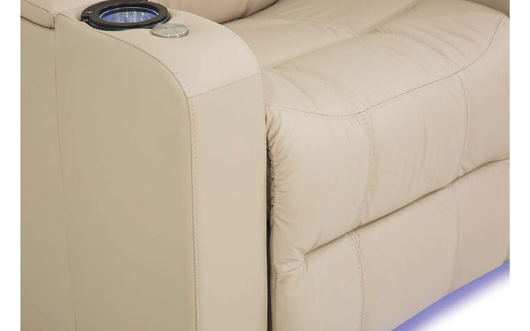 Close up shot of tan leather upholstery on theatre seat and bottom chair lights