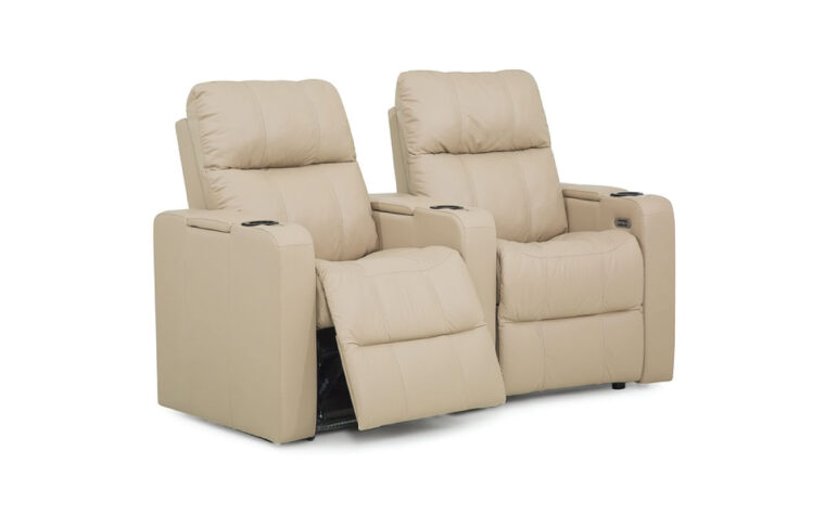 Angle view of two tan leather upholstered theatre seats with recliner extended