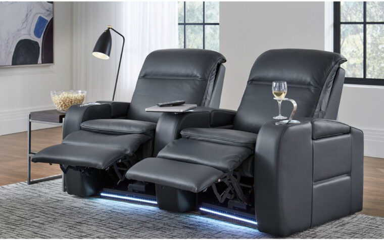Two black chairs in living room with recliners extended