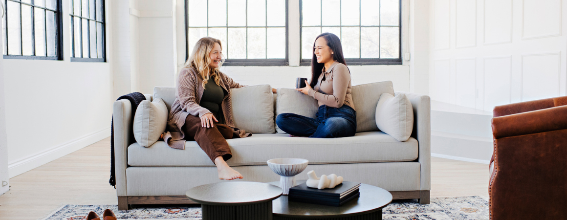two ladies sitting on a custom sofa chatting