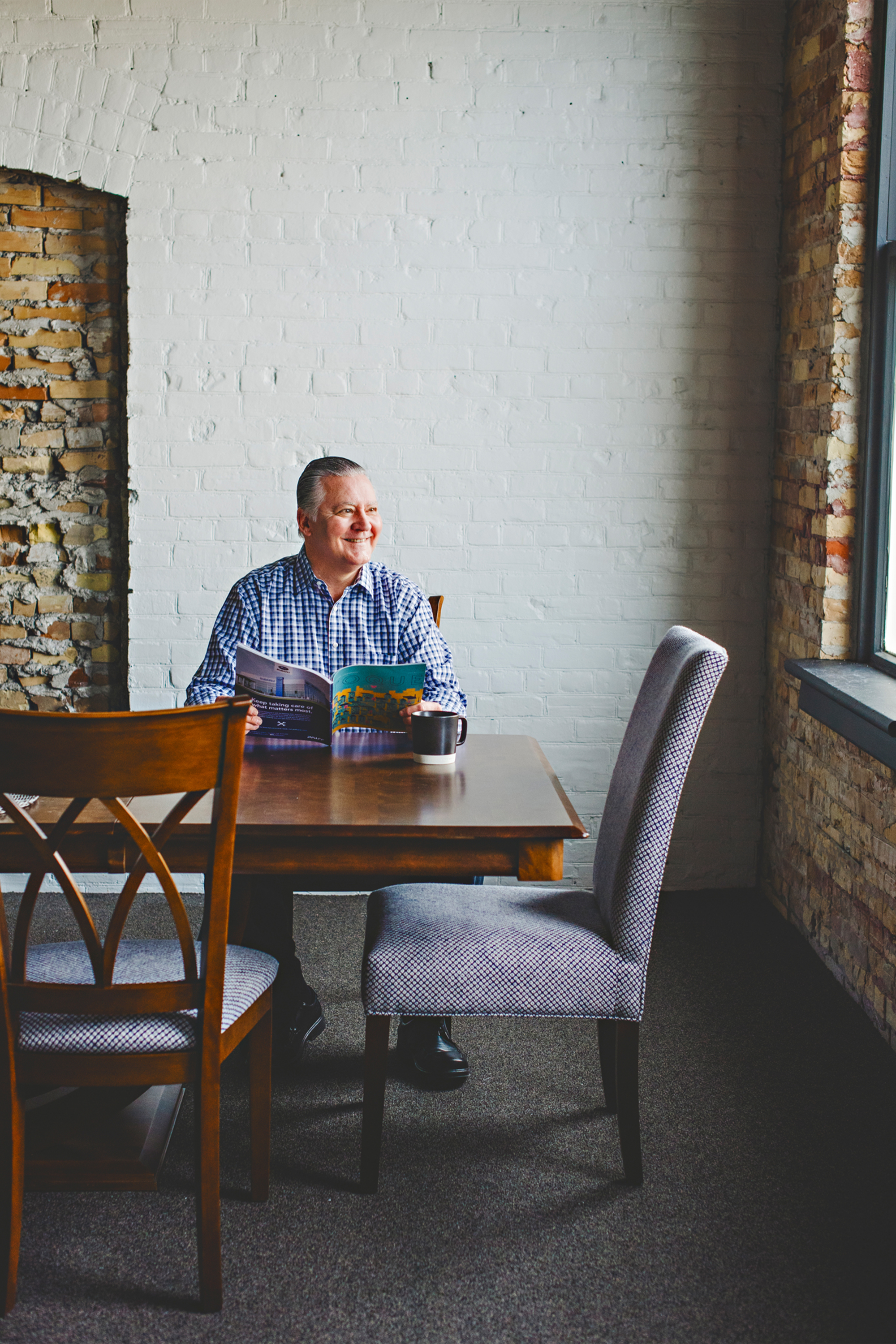man in elmira sitting at a solid wood dining table
