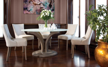A custom dining room with solid wood round table and upholstered beige chairs