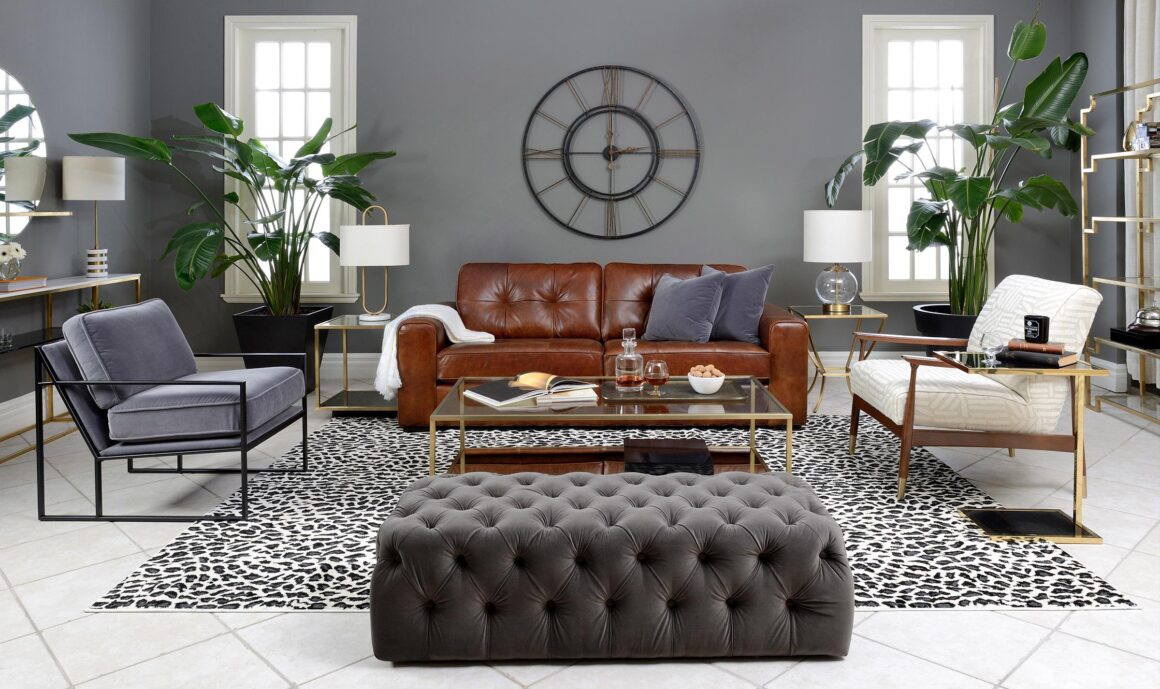 A living room setting with a warm leather sofa, and metala nd fabric accents chairs in contrasting finishes,.