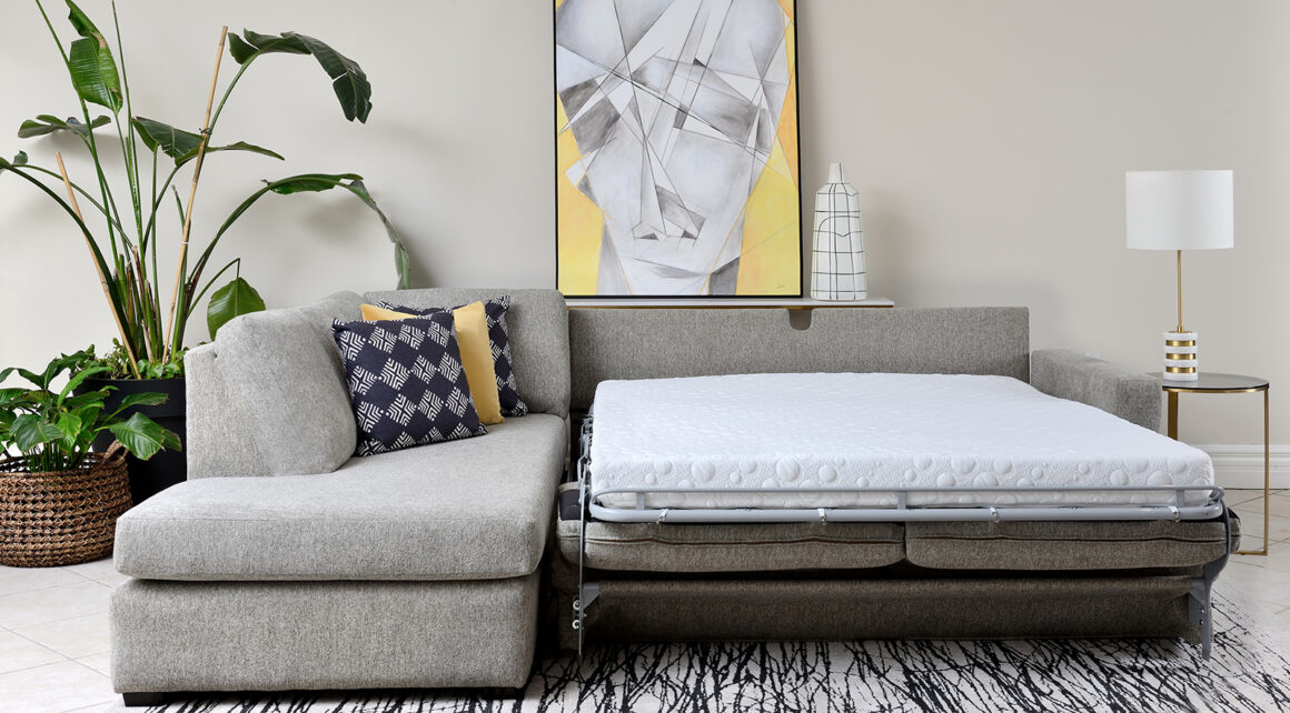 A light grey sleeping sofa sectional with the mattress opened by Decor-Rest.
