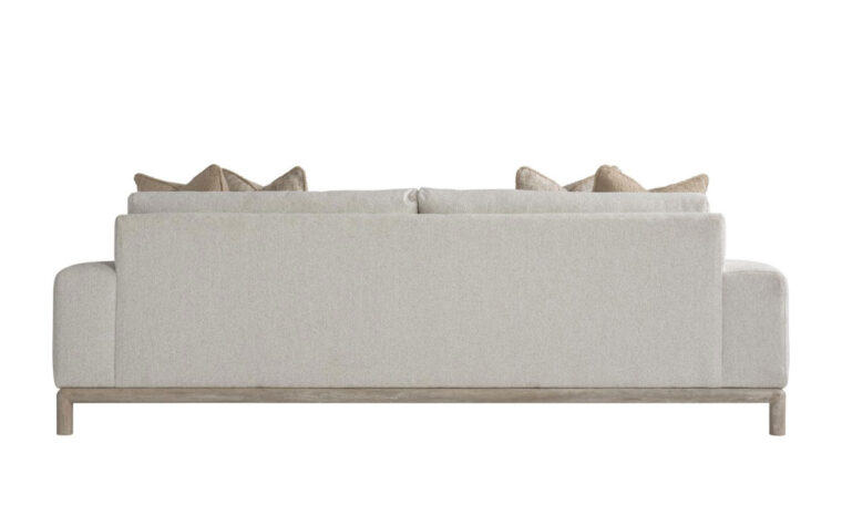 Back view of the sleek, modern Hadley sofa with a light wood frame shown in a cream fabric with 2 brown and beige throw pillows on either side