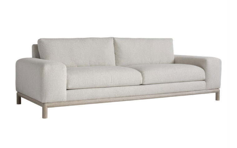 Angled view of the sleek, modern Hadley sofa with a light wood frame shown in a cream fabric