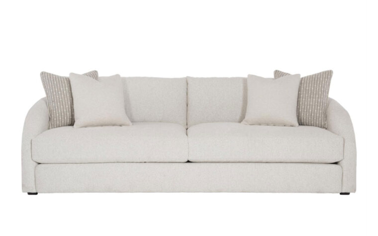 The modern Terra sofa with curved arms from Bernhardt in a cream fabric with two cream and beige throw pillows on either side