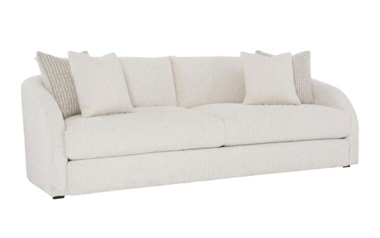 Angled view of the modern Terra sofa with curved arms from Bernhardt in a cream fabric with two cream and beige throw pillows on either side
