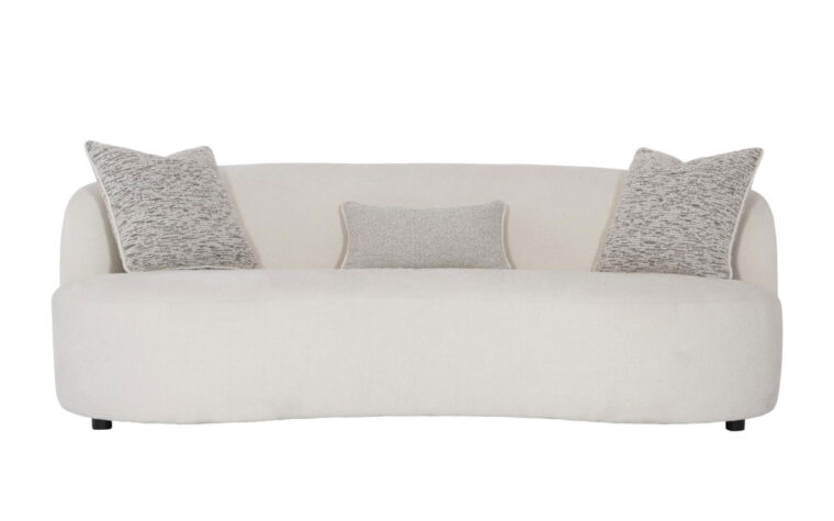 The Elle modern curved sofa from Bernhardt in a cream boucle fabric with three speckled gray throw pillows and dark wood feet