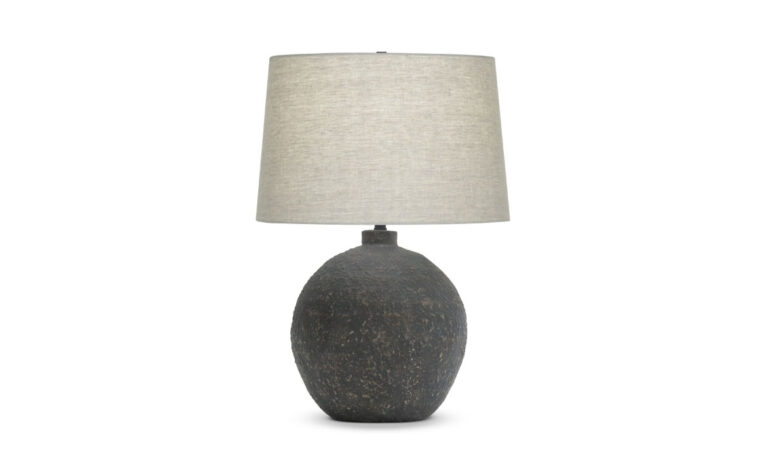 A modern table lamp with a brown ceramic base and beige linen lamp shade.