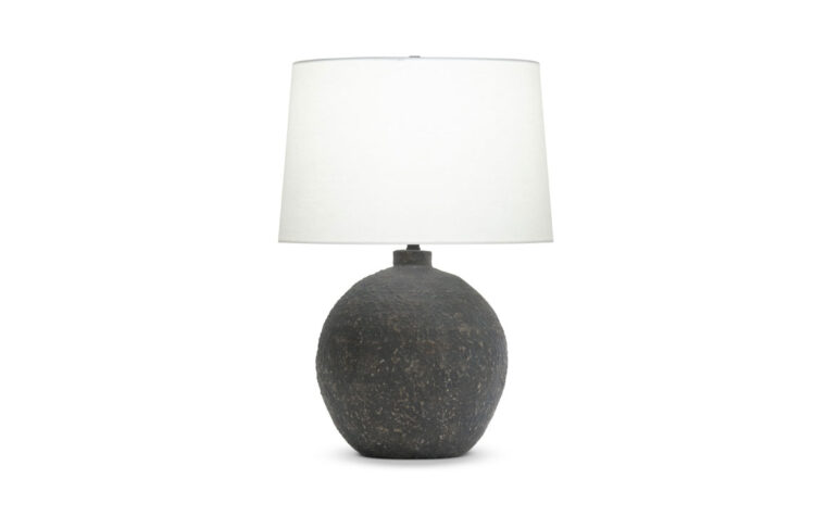 A modern table lamp with a brown ceramic base and off-white linen lamp shade.