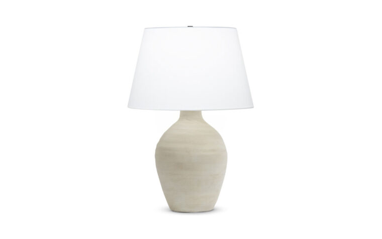 A organic table lamp with a cream ceramic base and a off-white cotton lamp shade.