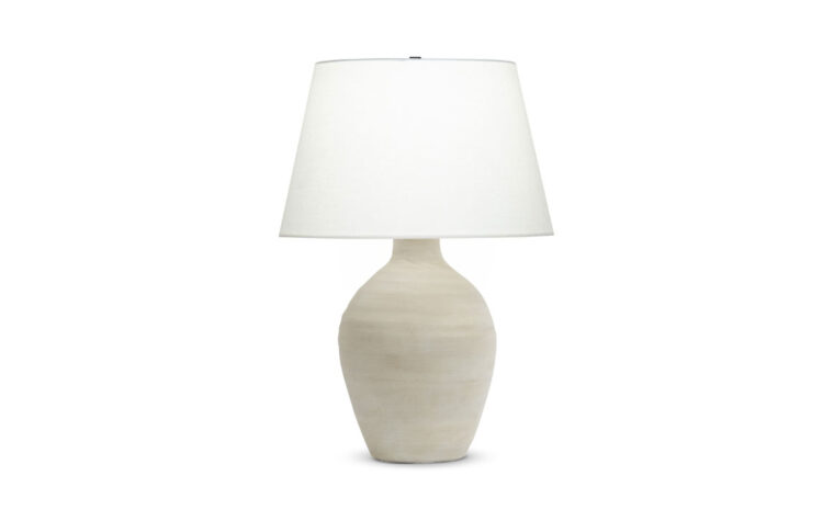 A organic table lamp with a cream ceramic base and a off-white linen lamp shade.