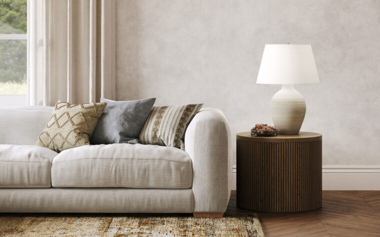 An organic table lamp with an off-white linen lampshade on a side table in a living room setting.