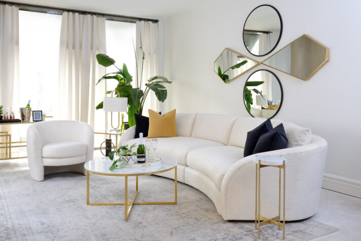 White curved modern sofa styled with golden accent furniture