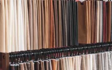 Two long racks of fabric samples ranging from white to all shades of warm toned browns