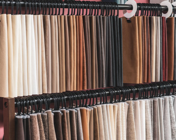 Two long racks of fabric samples ranging from white to all shades of warm toned browns