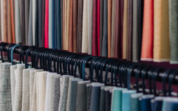 Two long racks of fabric samples hanging in various colours