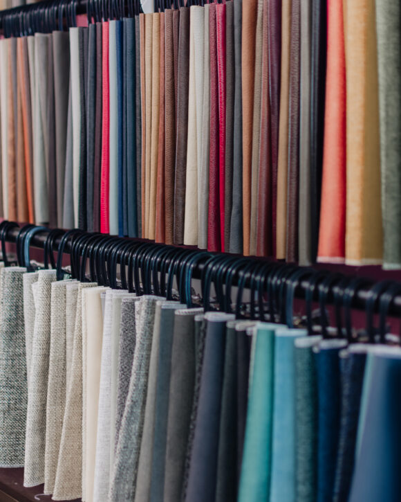Two long racks of fabric samples hanging in various colours