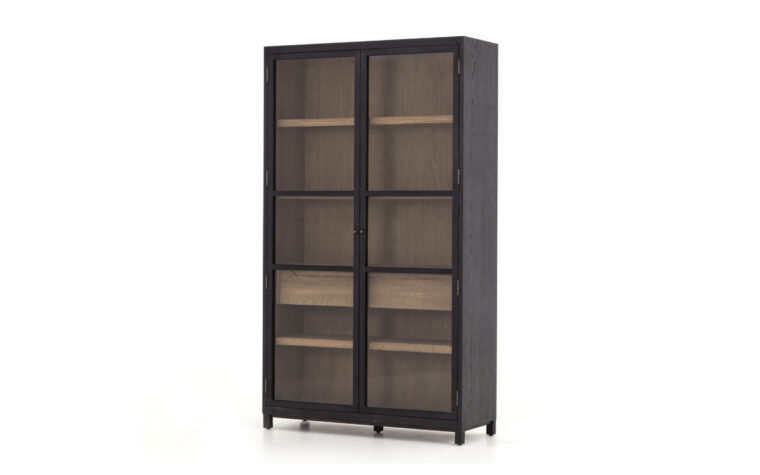 A slanted view of the Millie Oak Cabinet by Four Hands in drifted matte black with tempered glass doors.