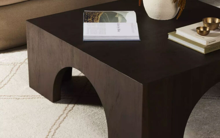The Fausto dark wood coffee table by Four Hands in a living room setting, also available in Bleached wood.