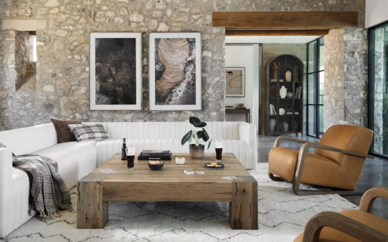 The Abaso Rustic Coffee Table by Four Hands in Rustic Wormwood Oak in a living room.