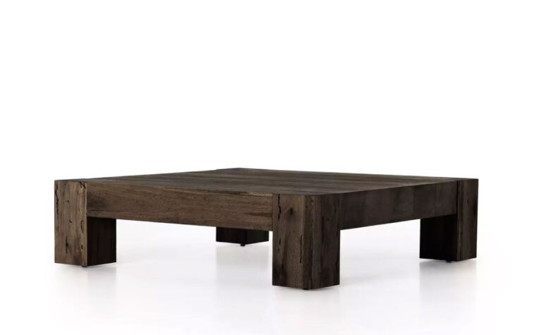 an angled view of The Abaso Rustic Coffee Table by Four Hands in Ebony Rustic Wormwood Oak.