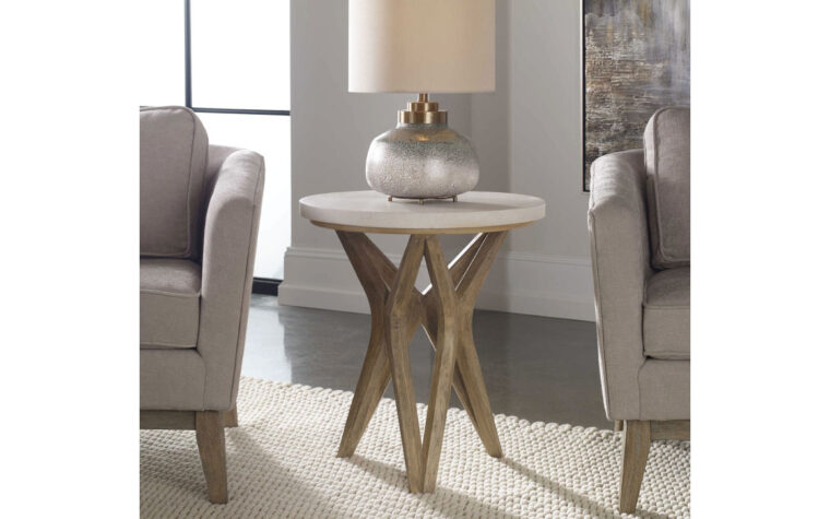 The Marnie handcrafted wood side table with ivory limestone tabletop placed in between two grey accent chairs.