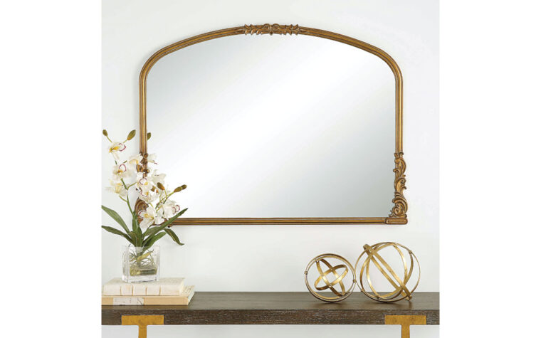 Antique Gold Arched Mirror by Uttermost hung on wall above console table.