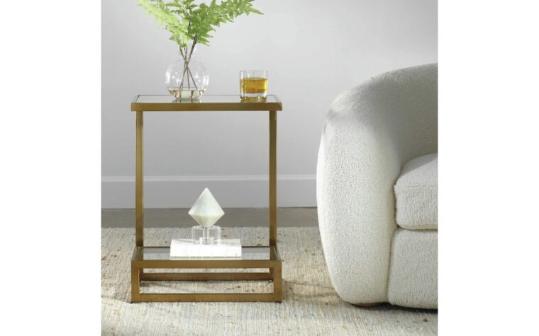 The musing glass side table with shelf by Uttermost styled beside grey accent chair.