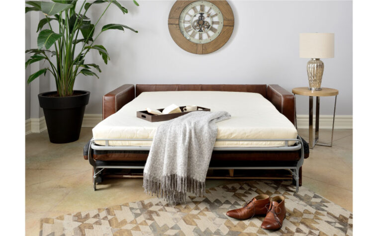 Brown leather sofa bed couch pulled out.