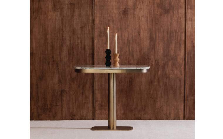 Celeste Green marble cafe table styled against wood background with two candles on top.