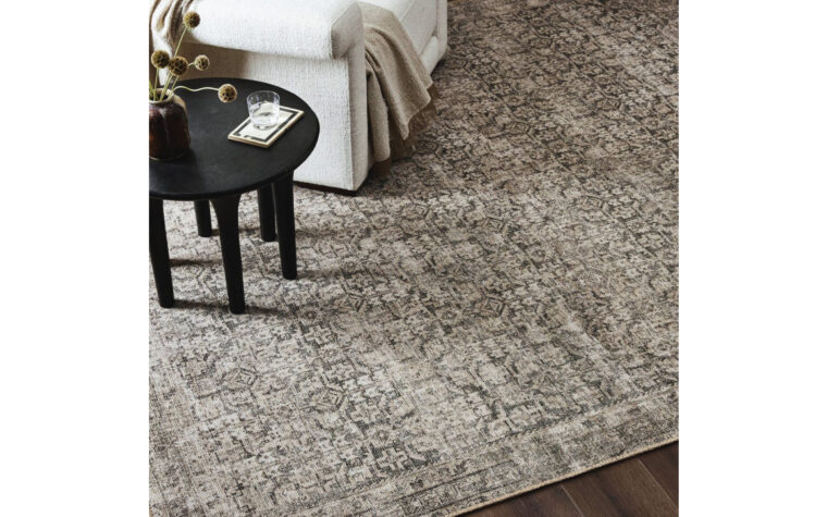 Priya Antique Area Rug from Four Hands in living room with chair and side table