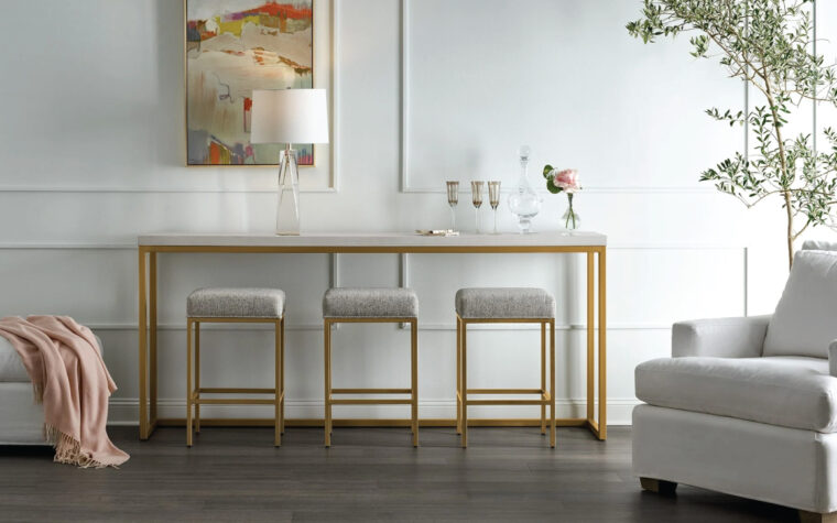 Modern console table and three stools with a gold metal base in a modern living room setting