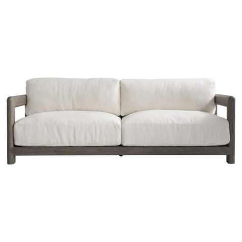 front view of the montaigne outdoor sofa in a weathered grey finish with white cushions with showwood arms and back